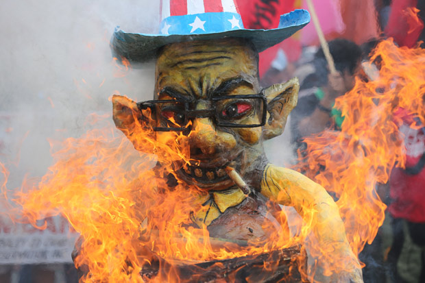 An effigy of Philippine President Benigno Aquino III burns during farmers' rally near his house a day before the Comprehensive Agrarian Reform program expires in suburban Quezon city, north of Manila, Philippines, on Sunday, June 29, 2014. The farmers group claimed that the land distribution program of the government is a failure, 26 years after it was implemented.