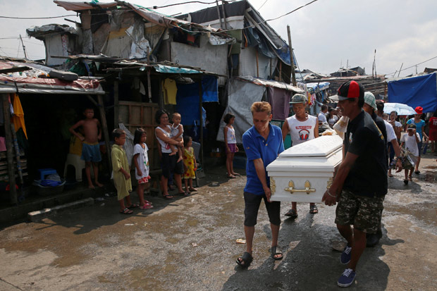 Neighbours watch as mourners carry the coffin of Vicente Batiancila, whom police said was among five victims of drug related killings three weeks ago, during his funeral in Navotas, Metro Manila in the Philippines, Octobe.