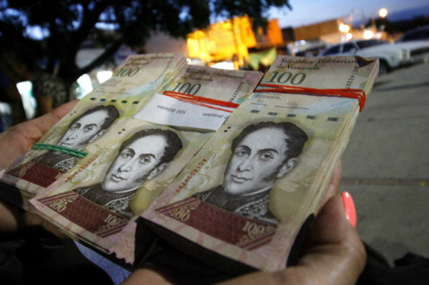 Mulher leva trs maos de 100 bolvares para trocar por pesos em Villa del Rosario, na Colmbia