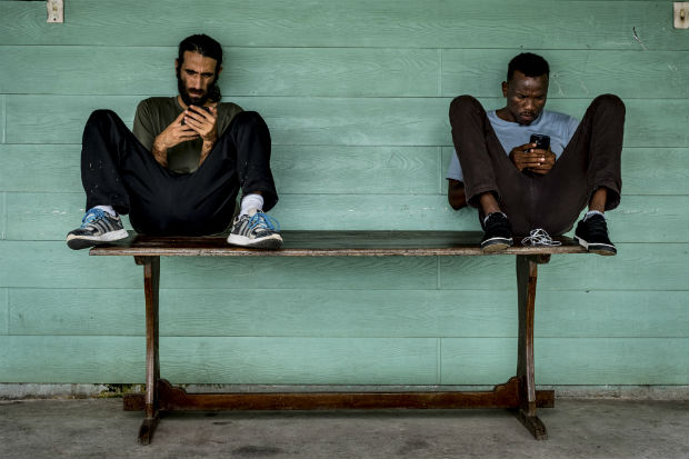 Abdul Aziz Muhamat (à dir.) e Behrouz Boochani, passam o tempo em Manus, na Papua Nova Guiné