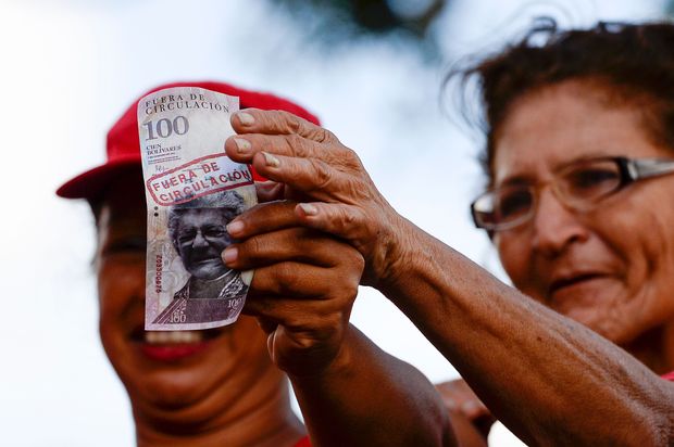 Partidrios do presidente Nicols Maduro seguram nota 100 bolvares em manifestao