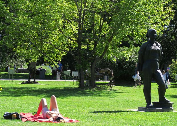 Moscovita toma sol perto de esttua em homenagem  me sovitica, em parque de esculturas