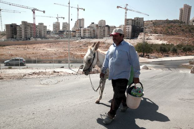 Palestino caminha em rea de construo de apartamentos israelenses em bairro de Jerusalm Oriental