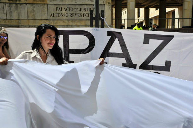 Uma mulher segura uma bandeira branca em um ato pelo acordo de paz com as Farc em Bogot