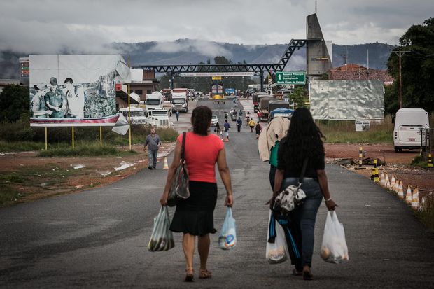 Mulheres venezuelanas voltam a seu pas com comida comprada no comrcio de Pacaraima (RR)