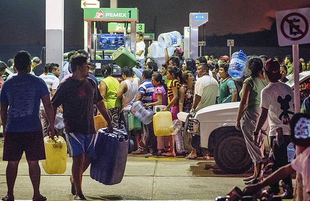 Residents steal gasoline and diesel from a gas station following protests against an increase in fuel prices in Allende, southern Veracuz State, Mexico, late Tuesday Jan. 3, 2017. The gas station attendants who had turned off the power to inactivate the pumps were intimidated by demonstrators into turning them back on, and allowing the residents to take the fuel. Nationwide protests continued as small groups shut down or looted gas stations and blocked roads to protest a price deregulation that has sent the cost of fuel up by as much as 20 percent. (AP Photo/Erick Herrera) ORG XMIT: NC102