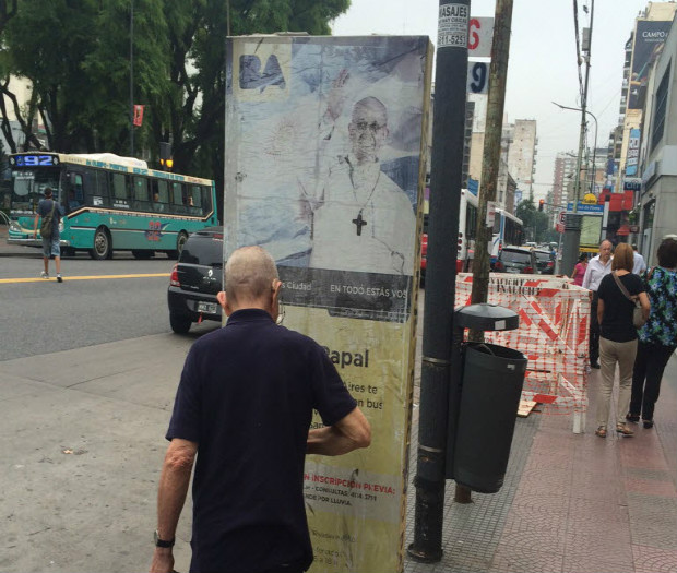 Pedestre olha uma das placas do Tour Papal em Flores, bairro de Buenos Aires onde nasceu Francisco