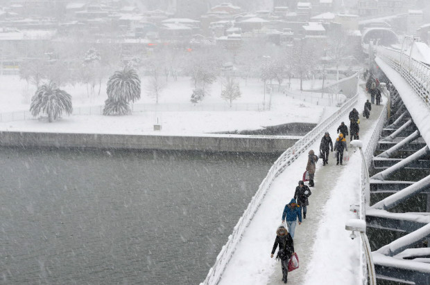 Pedestres andam por ponte que cruza o estreito de Bsforo, em Istambul, tomada pela neve
