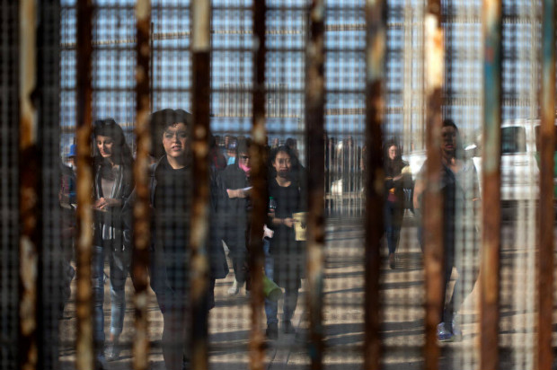 Moradores de San Diego, nos EUA, so vistos pela cerca que separa a cidade de Tijuana, no Mxico