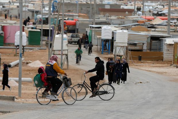 Syrian refugees ride bicycles on the main street of Al Zaatari refugee camp in Jordan, near the border with Syria, November 30, 2016.