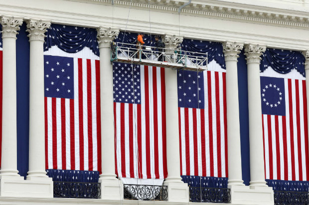Operrios preparam sequncia de bandeiras dos EUA na fachada do Capitlio para a posse de Trump