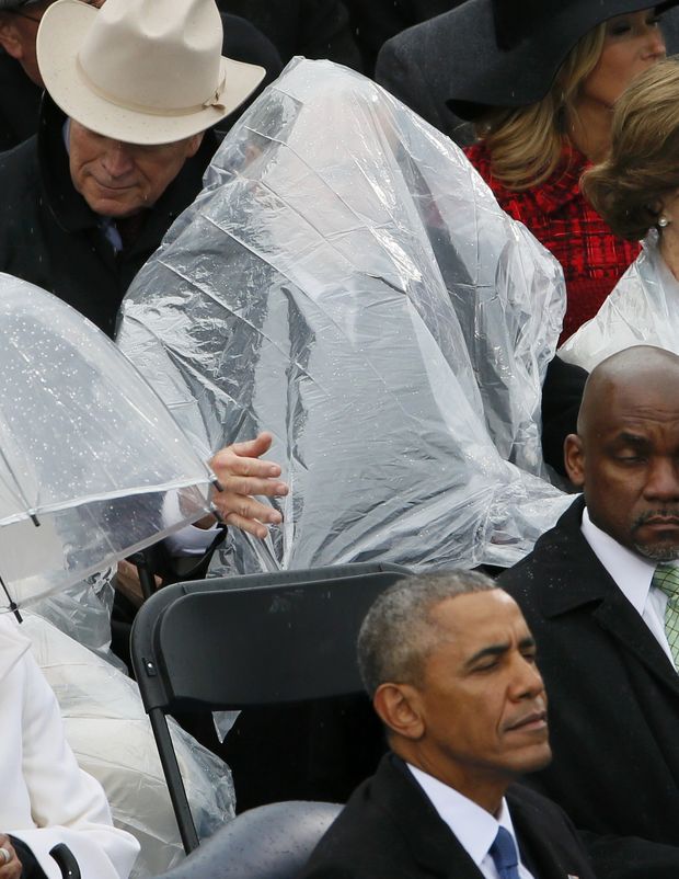 Former President George W. Bush keeps covered under the rain during the inauguration ceremonies swearing in Donald Trump as the 45th president of the United States on the West front of the U.S. Capitol in Washington, U.S., January 20, 2017.