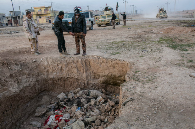 Diversos crnios e ossos so vistos em uma vala comum onde os mortos foram atirados em Mossul