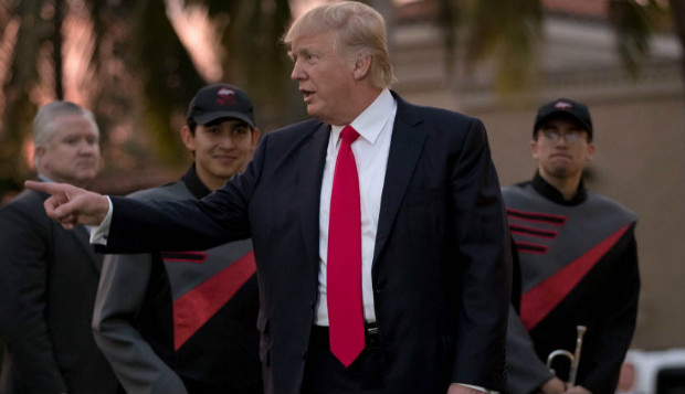 O presidente dos EUA, Donald Trump,  recebido por banda de msica em seu clube de golf no domingo