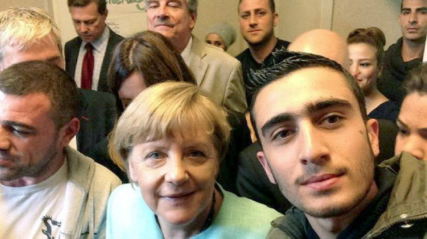Anas Modamani com Merkel; srio processa o Facebook por postagens que o associam ao terrorismo