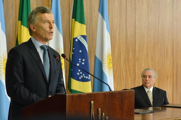O presidente argentino, Mauricio Macri, e o presidente Michel Temer (ao fundo), em evento em Braslia