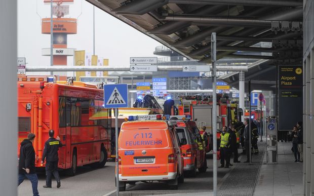 Ambulances stand outside the Hamburg, northern Germany, airport Sunday, Feb. 12, 2017 after several people were injured by an unknown toxic that likely spread through the airports' air conditioning system. (Axel Heimken/dpa via AP) ORG XMIT: MHBG106
