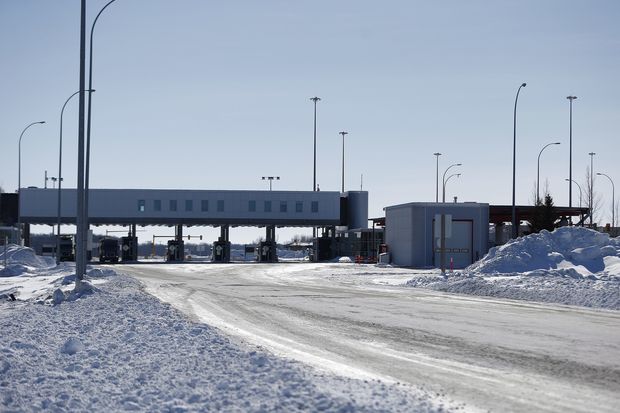 FILE- This Feb. 9, 2017, file photo shows the Canada and United States border crossing near Emerson, Manitoba. Desperate immigrants are flowing across the U.S. border into Canada. America’s neighbor to the north is increasingly being seen as a haven for asylum seekers turned away by the U.S., and are willing to chance a walk across the border in dangerous cold to get there. (John Woods/The Canadian Press via AP, File) ORG XMIT: NYJK107