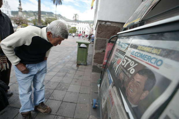 Homem l capa de jornal sobre a reeleio do presidente Rafael Correa em Quito, em 2013