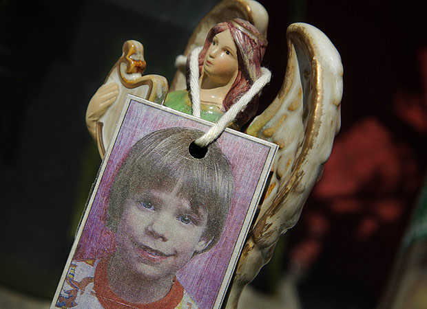 FILE- In this May 28, 2012 file photo, an image of Etan Patz hangs on an angel figurine, part of a makeshift memorial in the SoHo neighborhood of New York where the boy lived. Pedro Hernandez, a man unsuspected for decades in one of the nation's most haunting missing-child cases, has been convicted nearly 38 years after 6-year-old Patz disappeared in New York City. (AP Photo/Mark Lennihan, File) ORG XMIT: NYR101