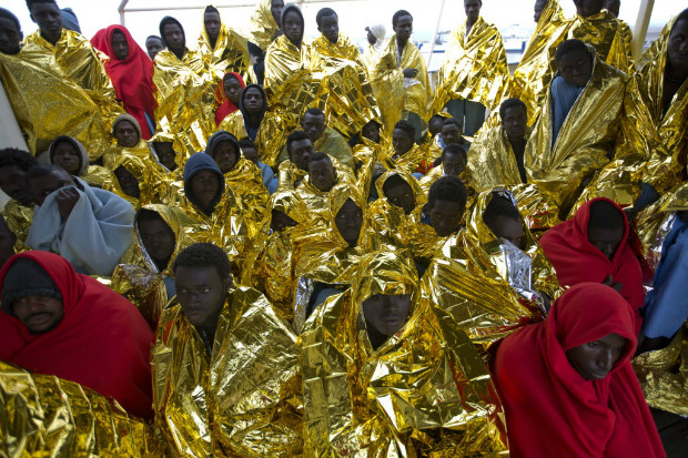 Imigrantes africanos se enrolam em lenis aps serem resgatados de barcos no mar Mediterrneo