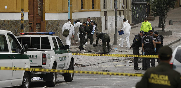 Police and investigators inspect the site where a homemade bomb exploded near the Santamaria bull ring in Bogota, Colombia, Sunday, Feb. 19, 2017. The artefact was detonated just a few hours before a scheduled bullfight, killing a police officer and injuring several dozen bystanders. (AP Photo/Ricardo Mazalan) ORG XMIT: XRM101