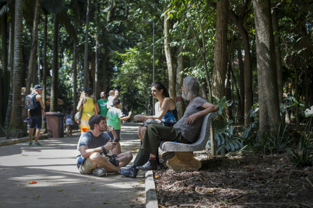 Dentro do parque, na zona oeste paulistana, Brandon Stanton conversa com idoso, ao lado da tradutora