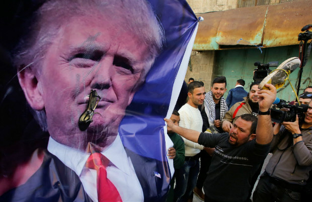 Palestino atira sapato contra um pster do presidente dos EUA, Donald Trump, em Hebron