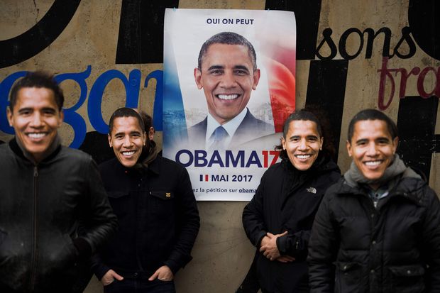 Apoiadores usam mscaras de Obama em frente a cartaz de candidatura do americano a presidente da Frana
