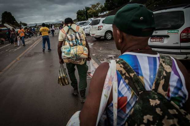 Grupo de venezuelanos levam para casa comida comprada na cidade brasileira de Pacaraima (RR)
