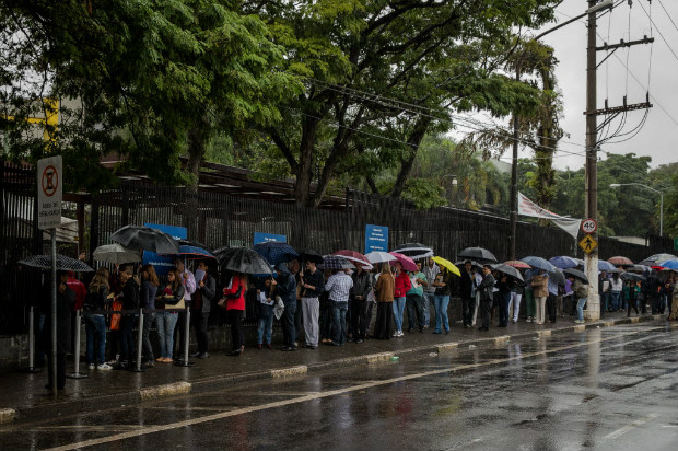 Pessoas que tentavam conseguir o visto americano fazem fila na porta do consulado em So Paulo