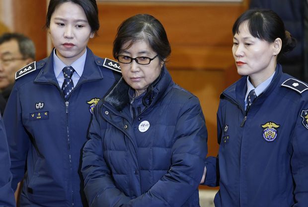 (FILES) This file photo taken on January 16, 2017 shows Choi Soon-sil (C), the woman at the centre of the South Korean political scandal and long-time friend of President Park Geun-hye, arriving for hearing arguments for South Korean President Park Geun-hye's impeachment trial at the Constitutional Court in Seoul. South Korean President Park Geun-Hye was fired by the country's top court on March 10, 2017, as it upheld her impeachment by parliament over a wide-ranging corruption scandal. Park was found to have broken the law by allowing her friend Choi Soon-Sil to meddle in state affairs, and breached rules on public servants' activities. / AFP PHOTO / POOL / KIM HONG-JI ORG XMIT: SEO103