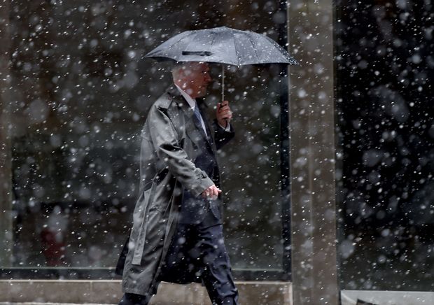  Blowing snow falls on a man outside the New York Stock Exchange on Wall Street in New York March 10, 2017 . Snow and frigid temperatures are expected in New-York city on the weekend. / AFP PHOTO / TIMOTHY A. CLARY ORG XMIT: TC010