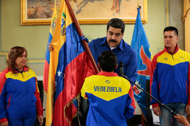 O presidente da Venezuela, Nicols Maduro, entrega bandeira a atleta juvenil que competir no Brasil