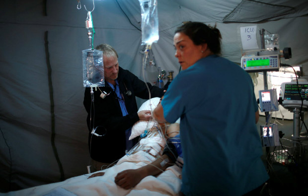 Mdicos atendem adulto civil ferido na batalha de Mossul no hospital de campanha em Bartella