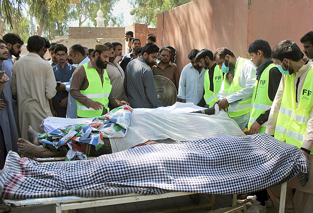 Pakistani volunteers and local residents gather around the bodies of people who were killed in a local shrine, outside the morgue of a hospital in Sarghodha, Pakistan, Sunday, April 2, 2017. Pakistani police say the custodian of the shrine and his accomplices have murdered 20 devotees in eastern Punjab province as part of a group cult ritual. (AP Photo/M.I. Haq) ORG XMIT: ISL101