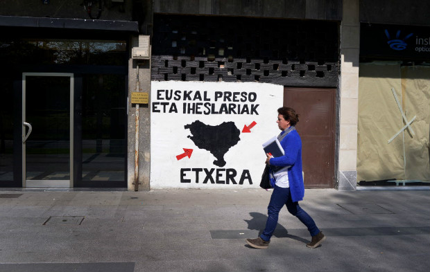 Pedestre passa por mural pedindo a liberação dos integrantes do ETA em Amorebieta, na Espanha