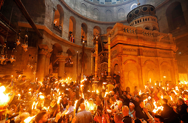 Christian Orthodox worshippers hold candles during the ceremony of the "Holy Fire" as thousands gather in the Church of the Holy Sepulchre in Jerusalem's Old City, on April 15, 2017, during the Orthodox Easter holy week. The ceremony celebrated in the same way for eleven centuries, is marked by the appearance of "sacred fire" in the two cavities on either side of the Holy Sepulchre. / AFP PHOTO / GALI TIBBON ORG XMIT: GAL000