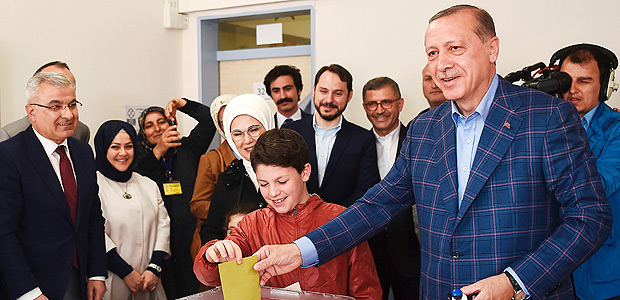 TOPSHOT - Turkish President Recep Tayyip Erdogan (R) casts his vote accompanied by his wife Emine Erdogan (3rd R) and their grandchildren during the referendum on expanding the powers of the president at a polling station in the Uskudar district of Istanbul, on April 16, 2017. Erdogan said the tightly-contested referendum on expanding the powers of the head of state was a vote for the future of Turkey. The first polling stations opened in the tightly contested referendum on expanding the powers of the president, seen as a crossroads in the modern history of the country. / AFP PHOTO / OZAN KOSE