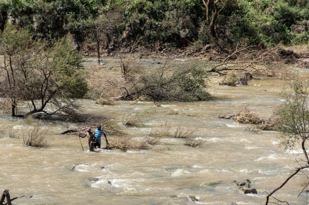 Dois garimpeiros procuram ouro com um detector de metal no rio Ncema em Matabeland, no Zimbbue