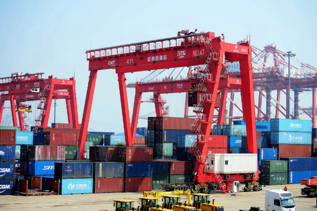 Contineres so transportados das docas para navios no porto de Qingdao, no nordeste da China
