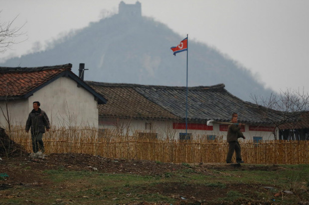 Agricultores norte-coreanos em plantao so vistos do lado chins do rio Yalu que divide os dois pases