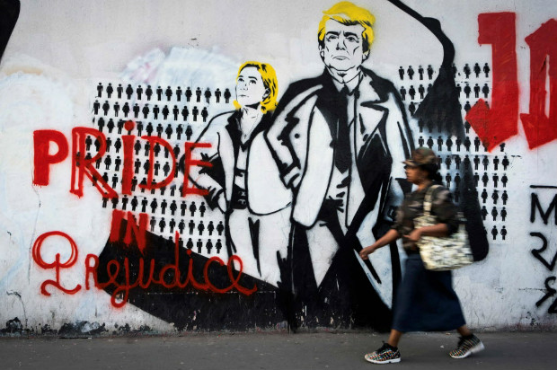 Grafite em Paris mostra a candidata da extrema direita francesa, Marine Le Pen, ao lado de Trump