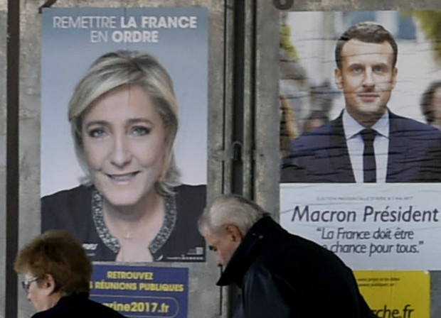 Cartazes de Marine Le Pen e Emmanuel Macron são vistos nas ruas de Valence d'Agen, no sul da França