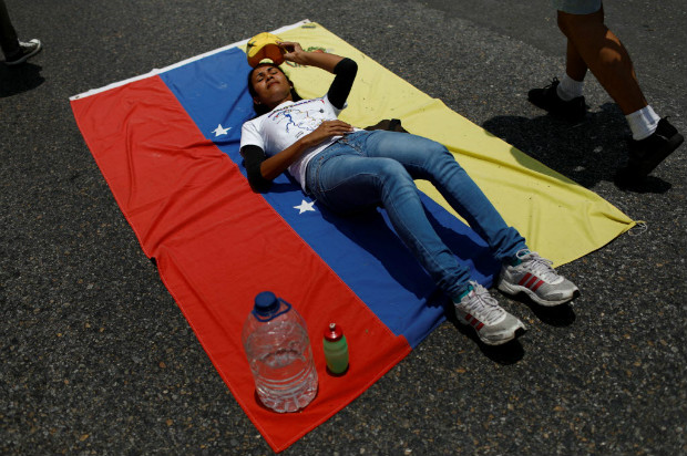 Manifestante opositora pega sol durante paralisao de uma das autoestradas de Caracas