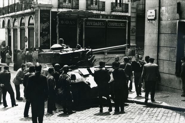 Em meio a curiosos e soldados, blindado cruza rua no bairro de Chiado, em Lisboa, em 25 de abril de 1974