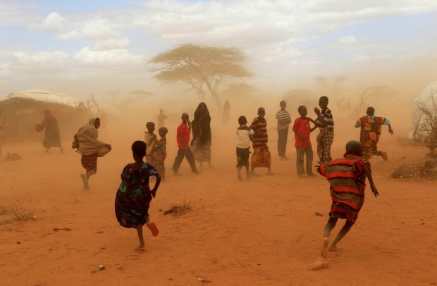 Somalis se protegem da poeira ao chegarem ao campo de refugiados de Dadaab, no Qunia
