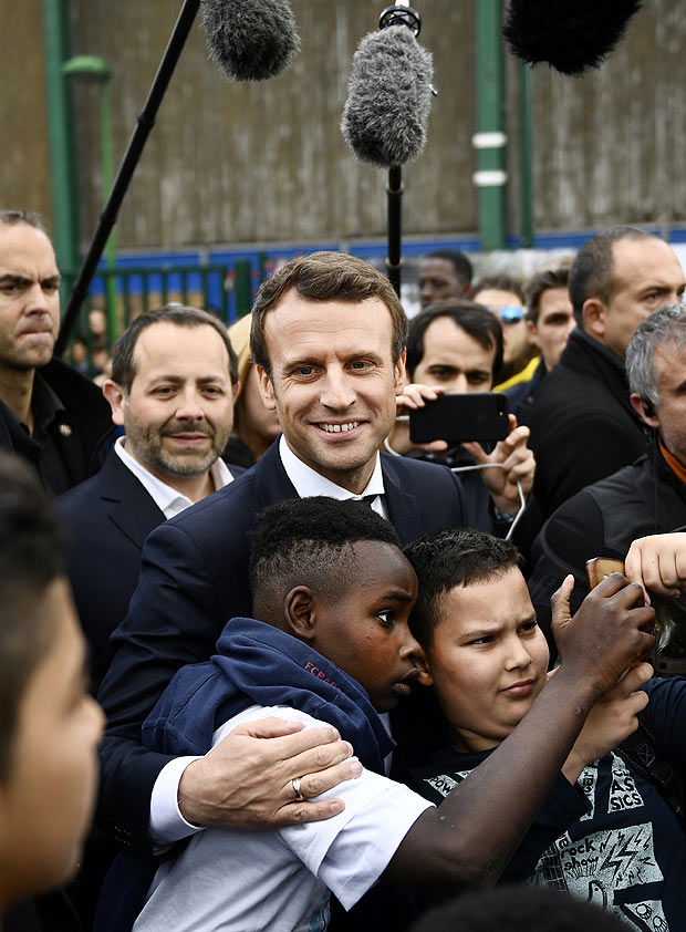 Emmanuel Macron (no centro), favorito na eleição francesa, faz corpo a corpo em Sarcelles, norte de Paris