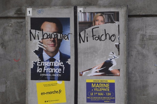 Cartazes de Macron e Le Pen s�o pichados com a frase 