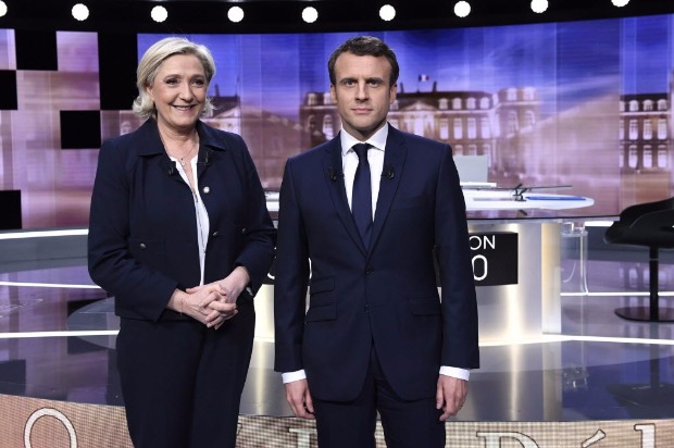 Candidates for the 2017 presidential election, Emmanuel Macron (R), head of the political movement En Marche !, or Onwards !, and Marine Le Pen, of the French National Front (FN) party, pose prior to the start of a live prime-time debate in the studios of French television station France 2, and French private station TF1 in La Plaine-Saint-Denis, near Paris, France, May 3, 2017. REUTERS/Eric Feferberg/Pool ORG XMIT: JES174